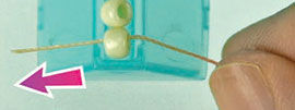 Thread being threaded through a bead